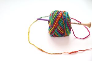 A photo of the rainbow-colored, 100% recycled silk yarn from the Budget-Friendly Crochet Subscription Box Darn Good Yarn of the Month