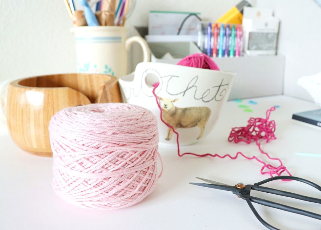 A photo of a skein of yarn wound up into a yarn cake using a ball winder. Using a yarn cake makes it easier to tension your yarn in crochet. Pictured is Lion Brand Yarn Coboo. - via  Sigoni Macaroni's latest blog post, 7 Constructive Tips to Improve Your Yarn Tension