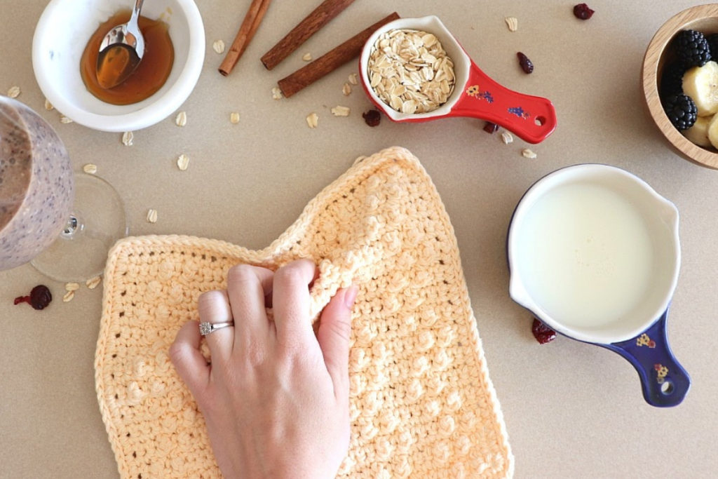 A photo of the treble pop washcloth crochet pattern in action. You can use crochet washcloths in the kitchen or in the bathroom.