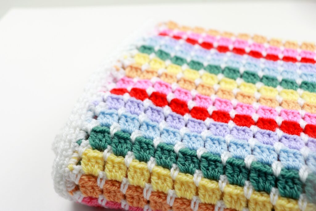 A close up of the block stitch used to create the striped Rainbow Baby Blanket crochet pattern