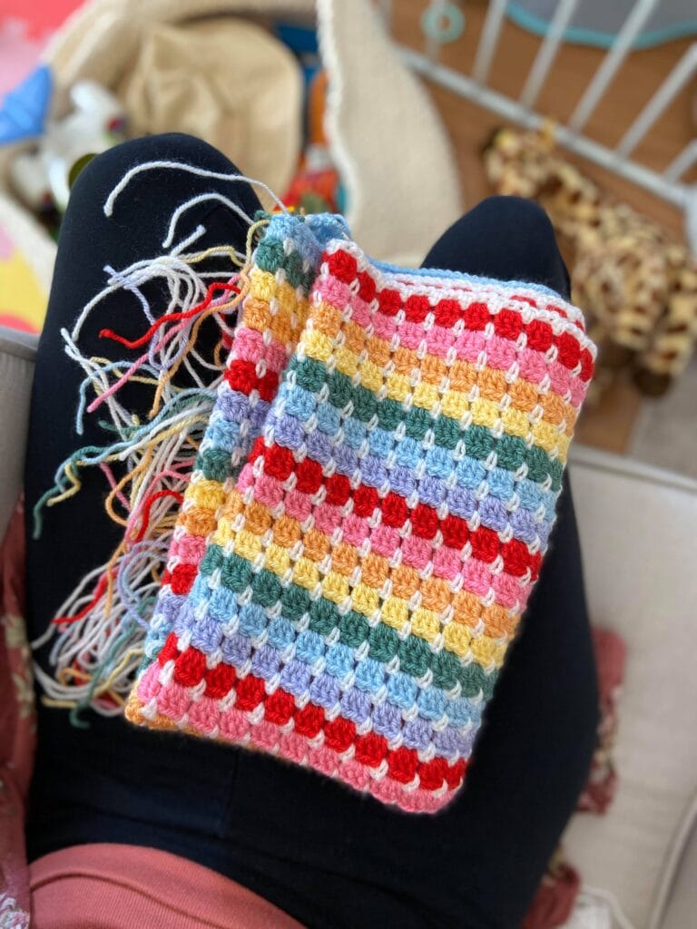 Rainbow crochet baby blanket with hundreds of unwoven ends