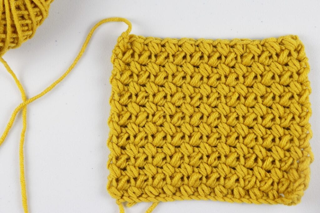 The finished Mini Bean Stitch swatch sample in the color purple using Milla Mia yarn.