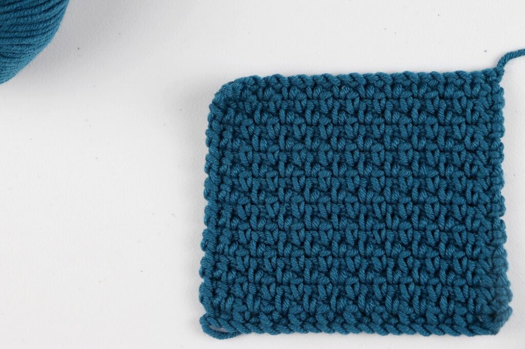 The finished Moss Stitch swatch sample in the color purple using Milla Mia yarn.